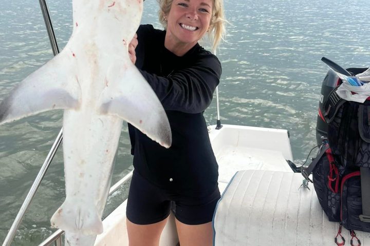 a person holding a fish on a boat in the water
