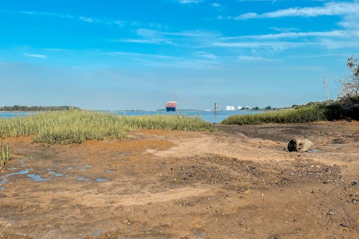 a sandy beach next to a body of water