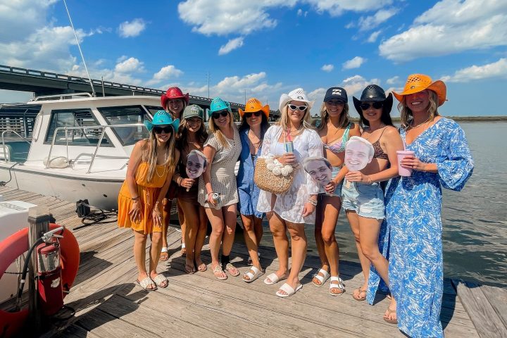 a group of people standing on a beach posing for the camera